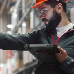 Man in warehouse holding rugged tablet