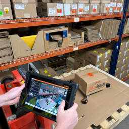 person using rugged tablet to dimension box on pallet